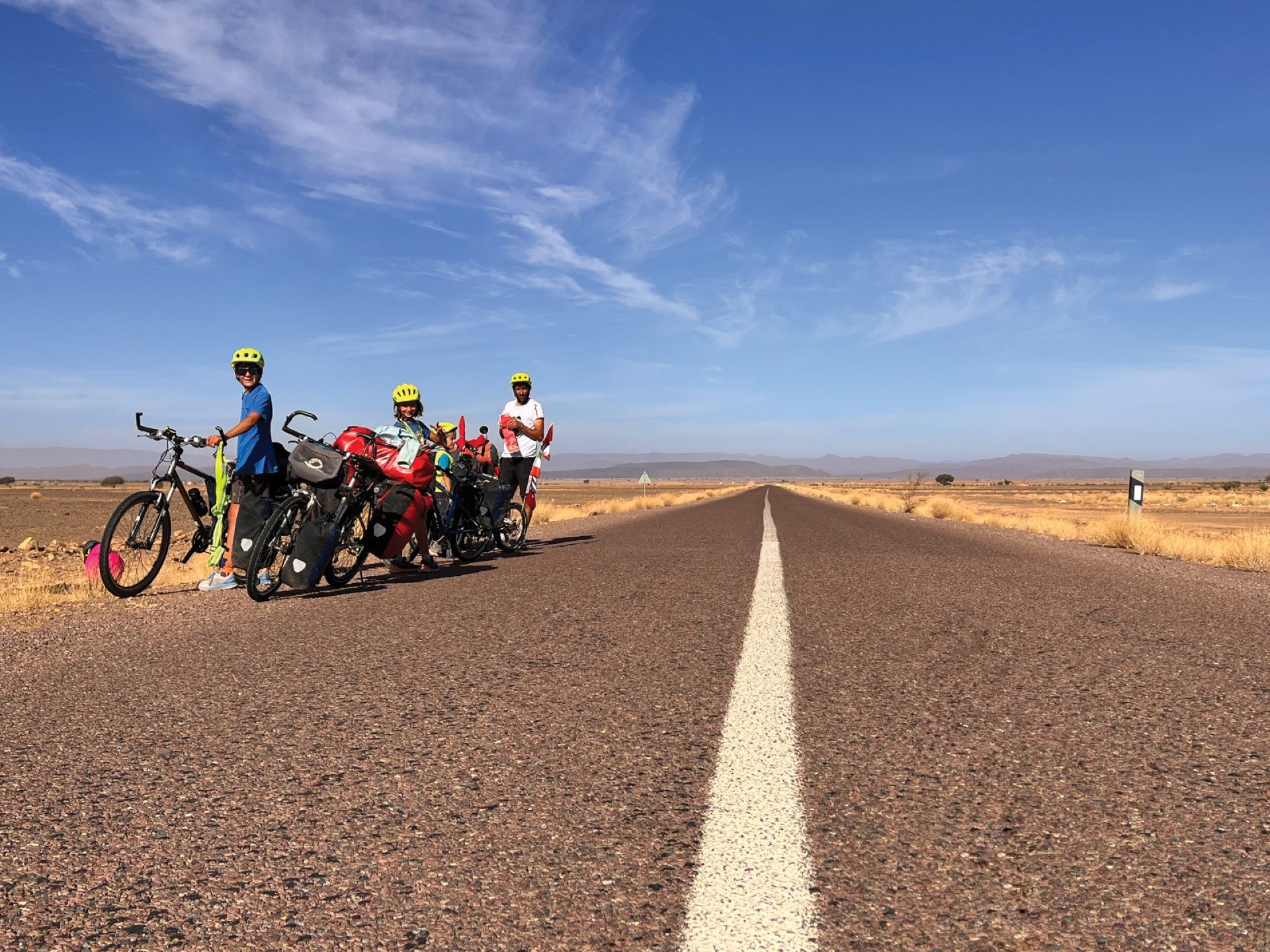 Famille à vélo sur une route au milieu du désert